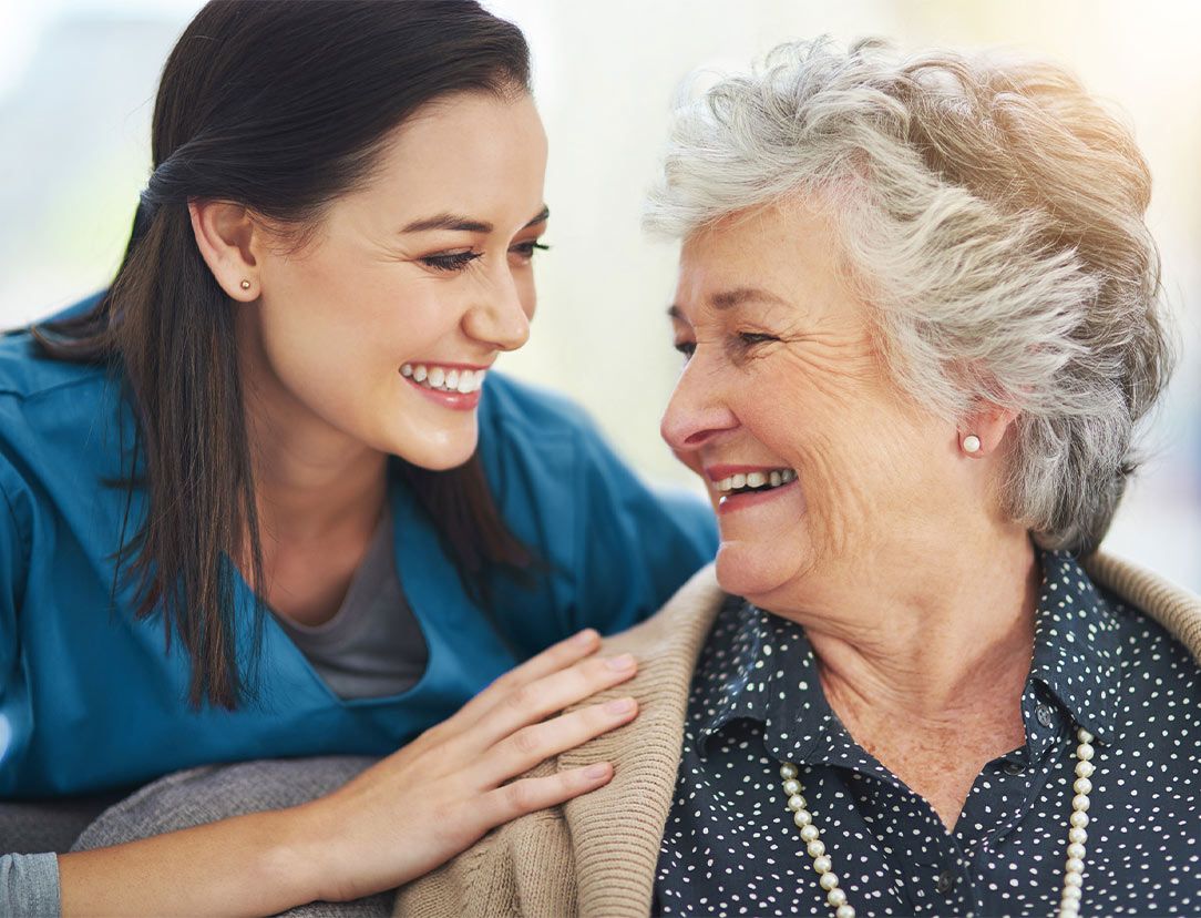 une auxiliaire de vie échange un moment convivial avec une personne âgée